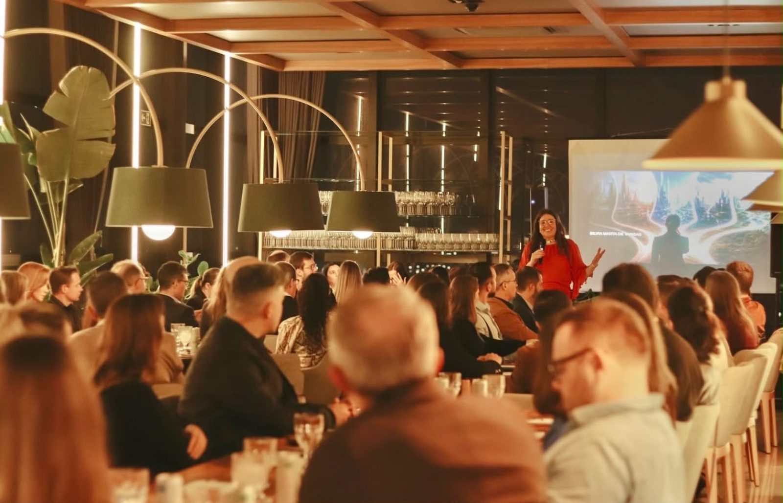 Silvia Marta de Vargas conduzindo um encontro, com a sala cheia